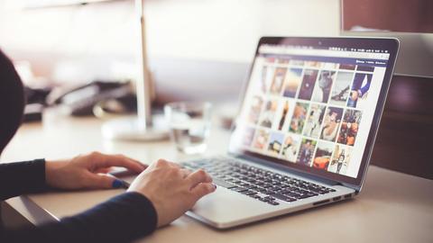 A person looking at photos on a laptop computer