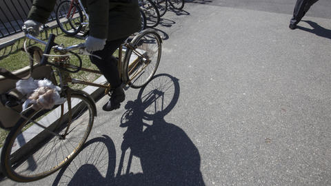Bicycle and cropped view of the rider casting a long shadow on the sidewalk