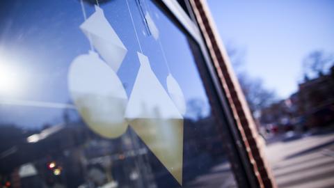 Window exterior with circle and diamond shaped ornaments hanging from the frame.