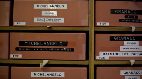 Close-up of storage compartments, with separate drawers labeled with artist names and types of materials.