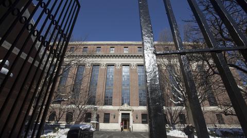 View of Widener Library in winter from outside an open gate.